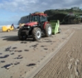 Oil Spill cleanup on beach with beach cleaning machine